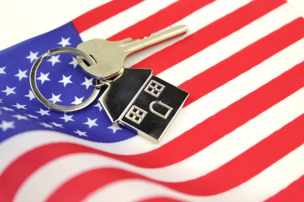 USA flag and key with house keychain. Concept of buying or renting home